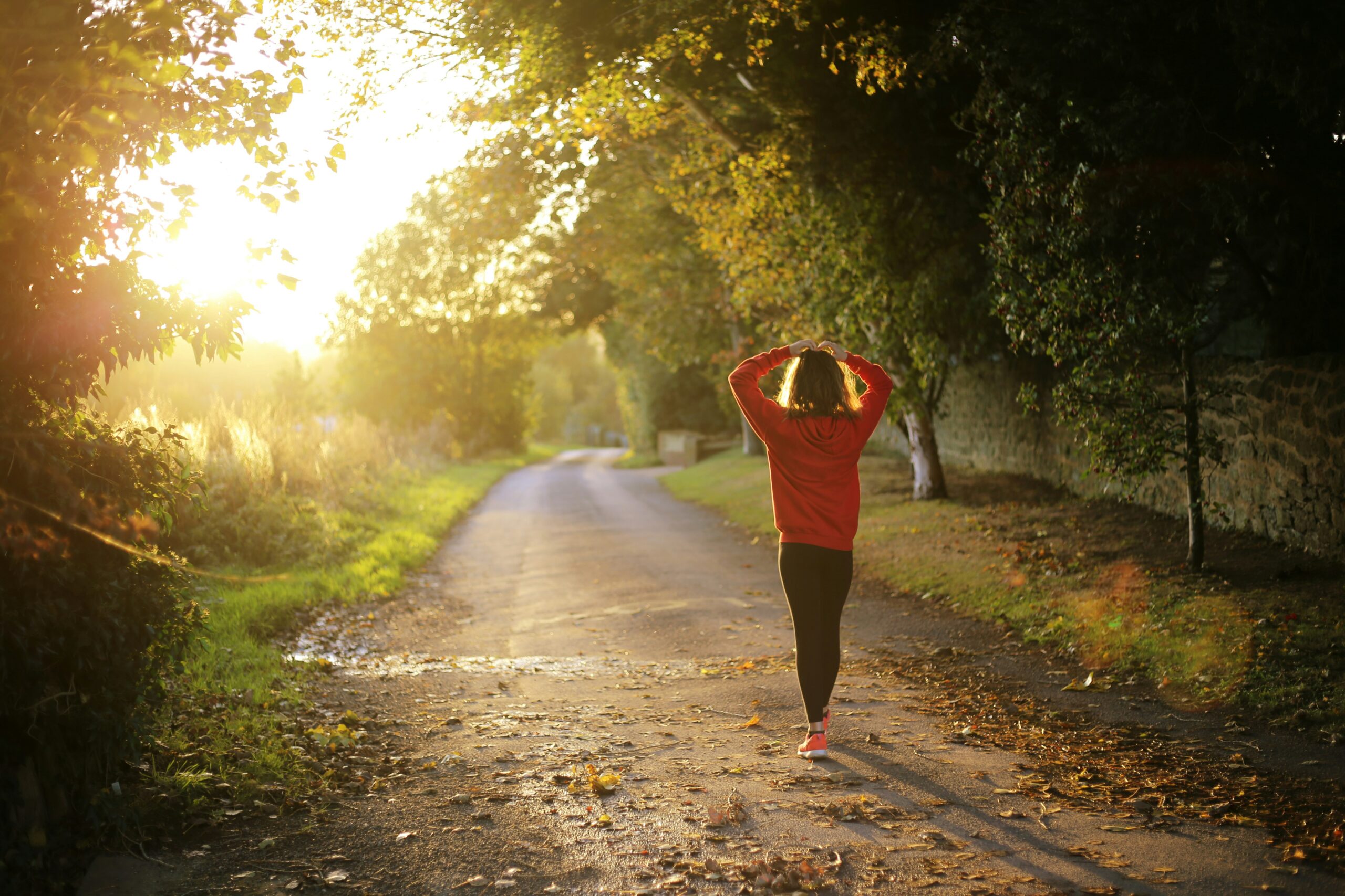 A lady walking in sunshine down a path depicting Health insurance in Arizona for Canadians.